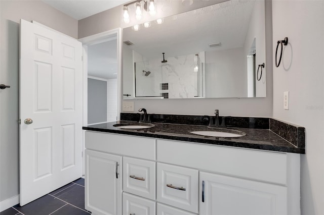 bathroom featuring walk in shower, vanity, a textured ceiling, and tile patterned floors