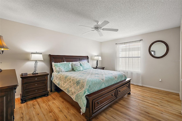 bedroom featuring light wood-type flooring, ceiling fan, and a textured ceiling