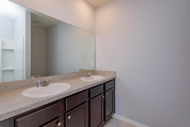 bathroom featuring vanity, tile patterned flooring, and toilet