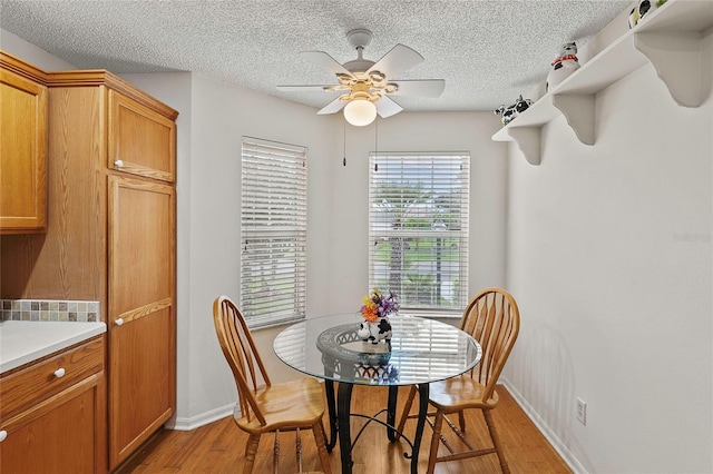 dining space featuring ceiling fan, a textured ceiling, and light hardwood / wood-style floors