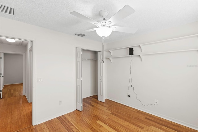 unfurnished bedroom featuring ceiling fan, a textured ceiling, and light wood-type flooring