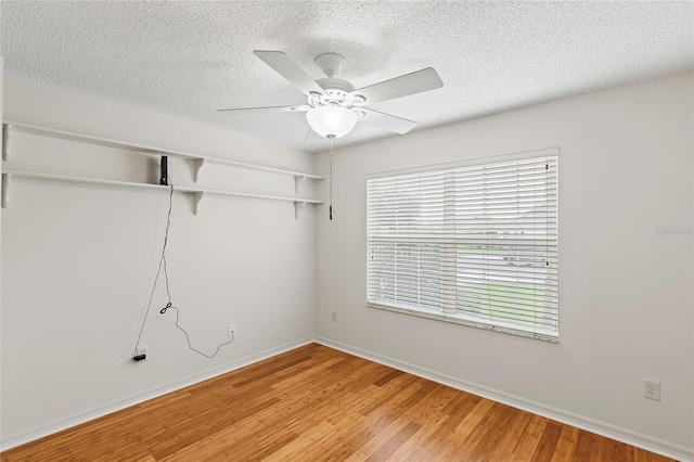 unfurnished room featuring a textured ceiling, hardwood / wood-style floors, and ceiling fan