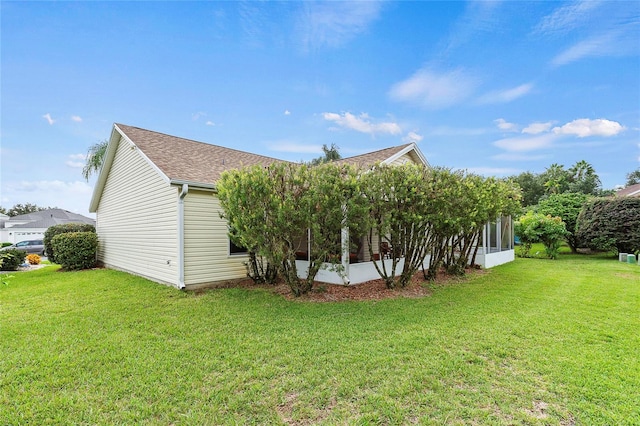 view of side of home featuring a sunroom and a yard