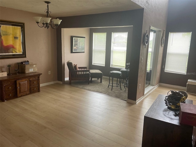 interior space featuring an inviting chandelier and light hardwood / wood-style flooring