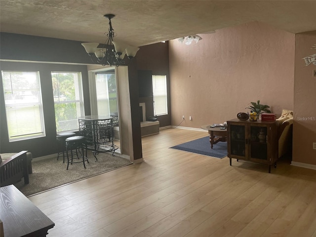 dining room featuring light wood-type flooring, a textured ceiling, and a chandelier