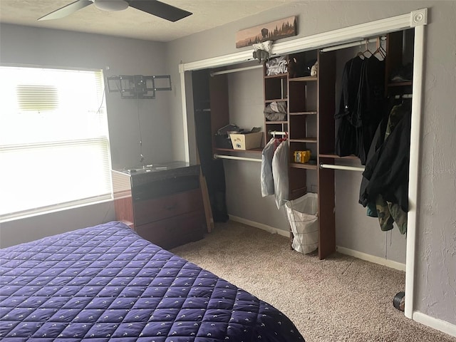 carpeted bedroom with ceiling fan, a textured ceiling, and a closet