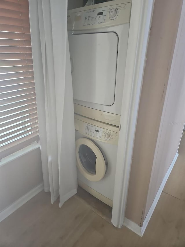 washroom featuring light hardwood / wood-style floors and stacked washer / drying machine