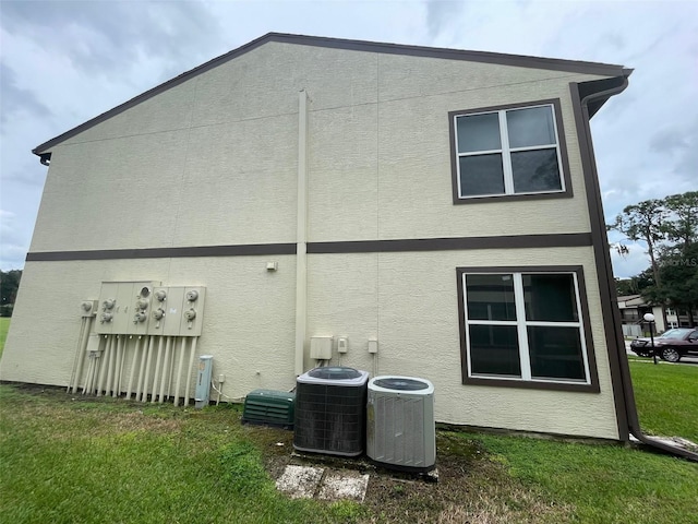 back of house with a lawn and cooling unit