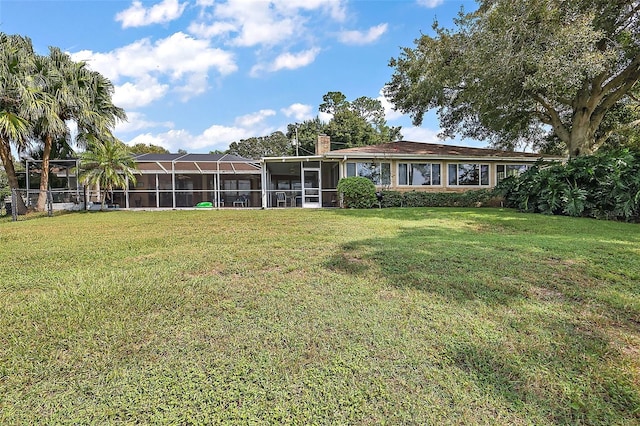 back of property featuring a lawn and a lanai