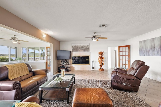 tiled living room with a tile fireplace and a textured ceiling