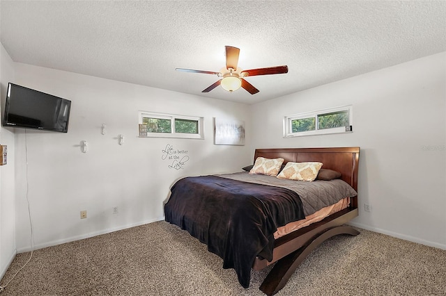 carpeted bedroom featuring a textured ceiling and ceiling fan