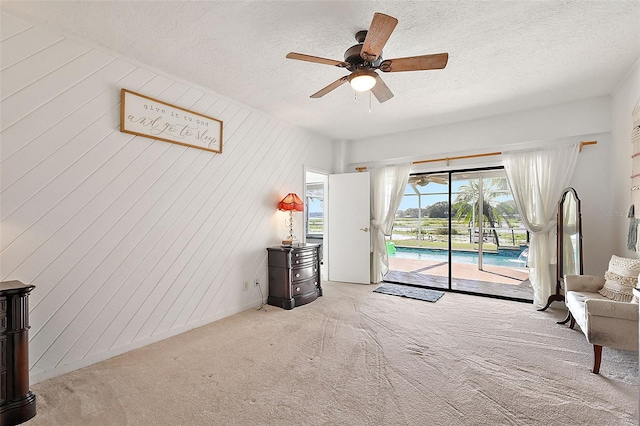 interior space with carpet, wood walls, a swimming pool, and ceiling fan