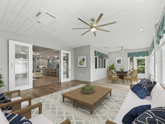 living room with wood-type flooring and ceiling fan