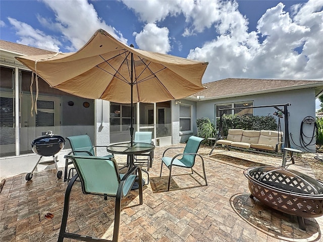 view of patio with an outdoor living space with a fire pit