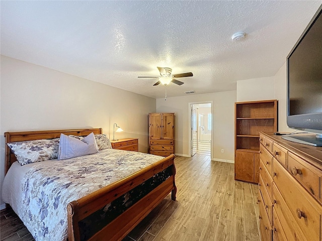 bedroom featuring light wood-type flooring, a textured ceiling, and ceiling fan