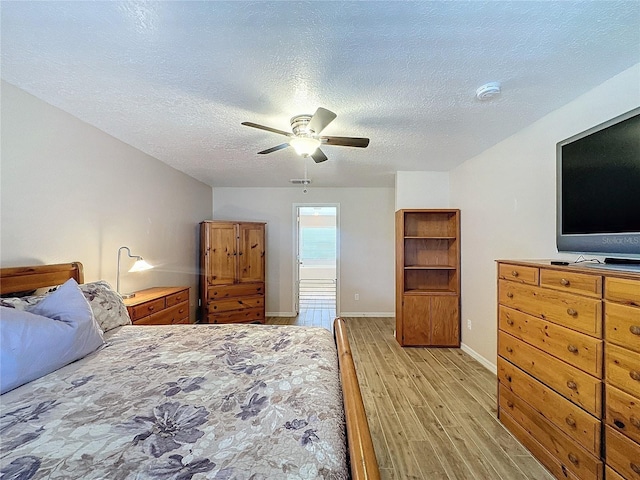 bedroom with light wood-type flooring, a textured ceiling, and ceiling fan