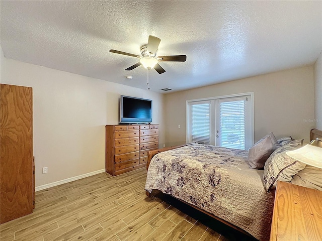 bedroom featuring ceiling fan, access to exterior, a textured ceiling, and light hardwood / wood-style floors