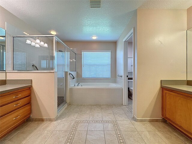 full bathroom featuring vanity, toilet, separate shower and tub, a textured ceiling, and tile patterned flooring