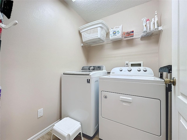 laundry area featuring washer and clothes dryer and a textured ceiling