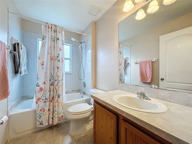 full bathroom featuring vanity, a textured ceiling, shower / bath combo with shower curtain, tile patterned floors, and toilet