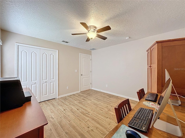 office space with ceiling fan, a textured ceiling, and light hardwood / wood-style flooring