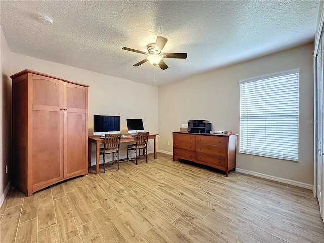 office area featuring light wood-type flooring, ceiling fan, and a textured ceiling