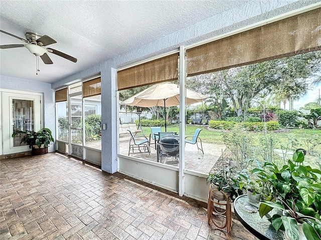 unfurnished sunroom featuring ceiling fan