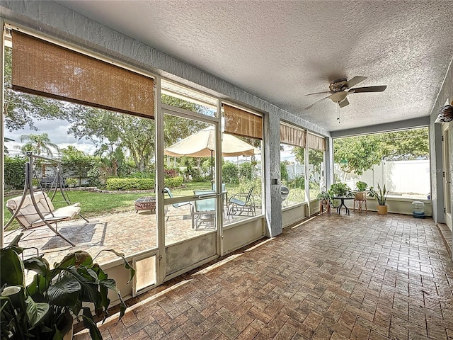 unfurnished sunroom featuring a healthy amount of sunlight and ceiling fan