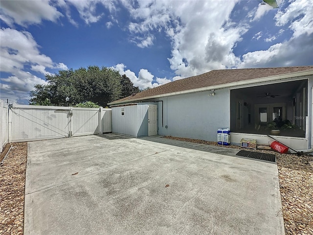 rear view of property with ceiling fan and a patio