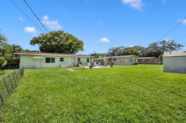 back of property featuring a shed, a yard, and a patio