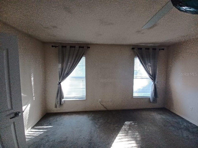 carpeted spare room with a textured ceiling