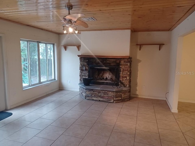 unfurnished living room featuring ceiling fan, a stone fireplace, wooden ceiling, and light tile patterned floors