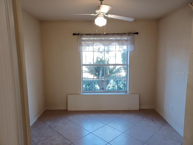 tiled spare room with ceiling fan