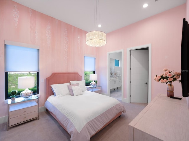 carpeted bedroom featuring ensuite bath, multiple windows, and a chandelier