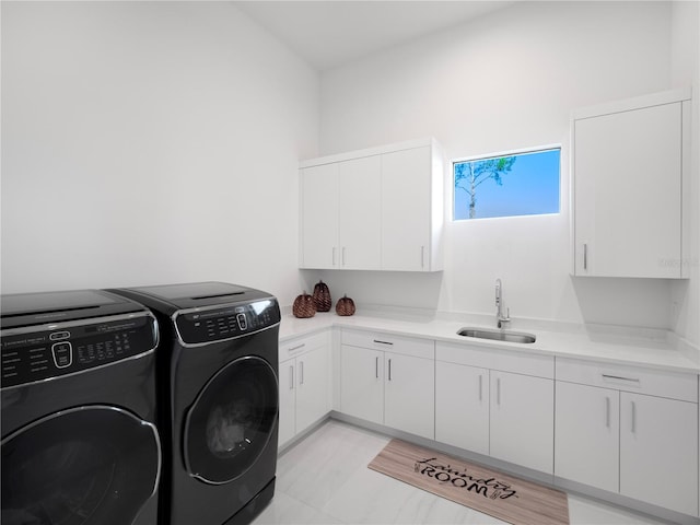 washroom featuring washing machine and clothes dryer, cabinets, and sink