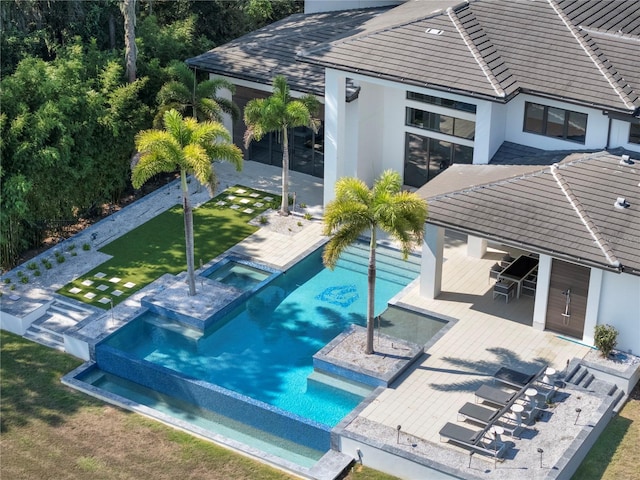 view of swimming pool with a patio and an in ground hot tub