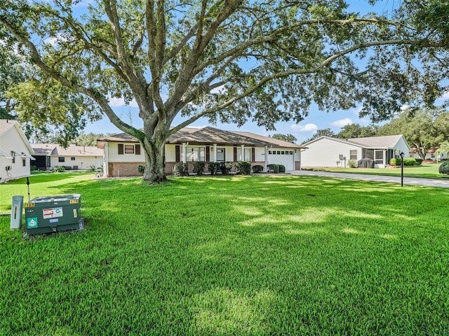 ranch-style home with a garage and a front lawn