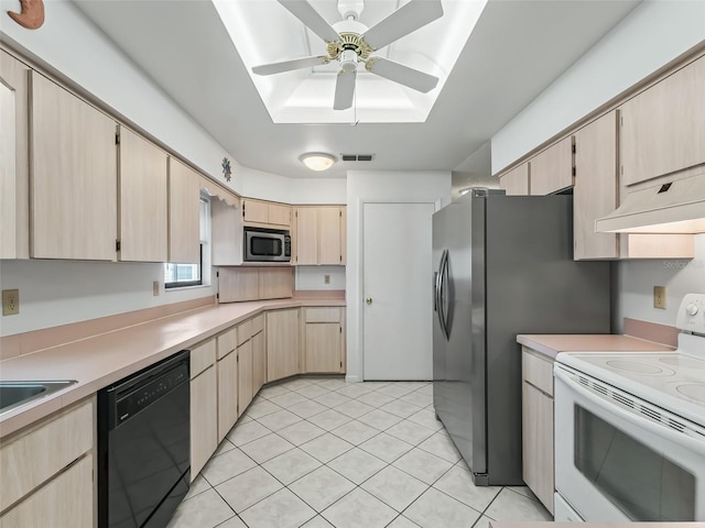 kitchen featuring stainless steel appliances, ceiling fan, light brown cabinets, and a skylight