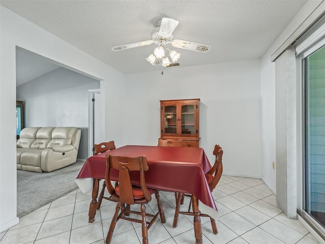 tiled dining area featuring ceiling fan and a textured ceiling