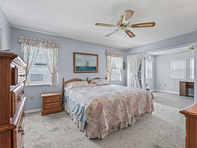 carpeted bedroom with ceiling fan and a textured ceiling