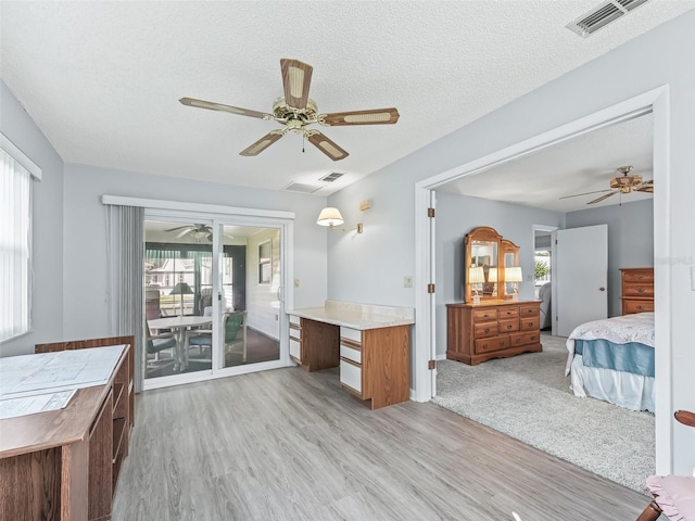 interior space featuring ceiling fan, hardwood / wood-style flooring, and a textured ceiling