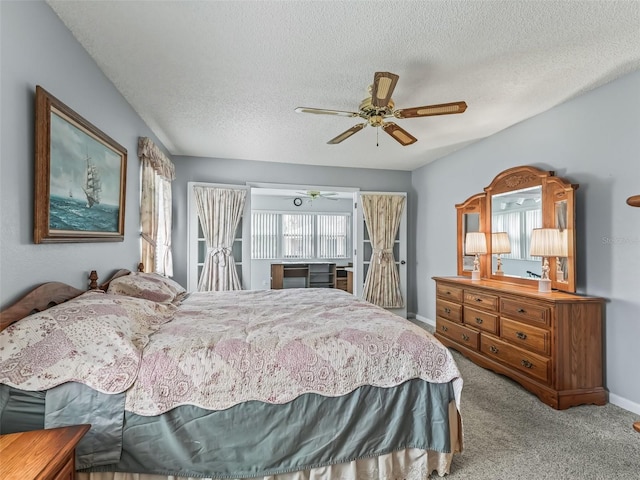 carpeted bedroom featuring ceiling fan and a textured ceiling