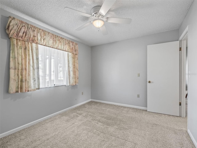 unfurnished room featuring a textured ceiling, light carpet, and ceiling fan