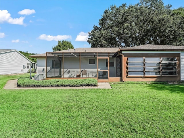 rear view of property featuring a lawn