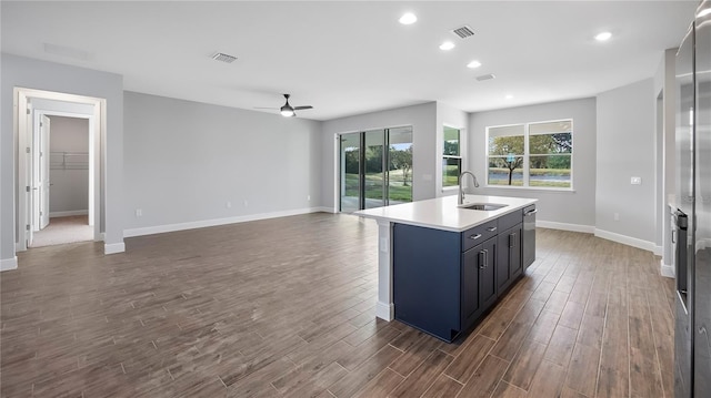 kitchen featuring dark hardwood / wood-style floors, sink, stainless steel dishwasher, ceiling fan, and a kitchen island with sink