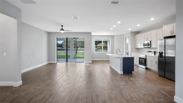 kitchen featuring stainless steel appliances, dark hardwood / wood-style floors, white cabinetry, and a kitchen island with sink