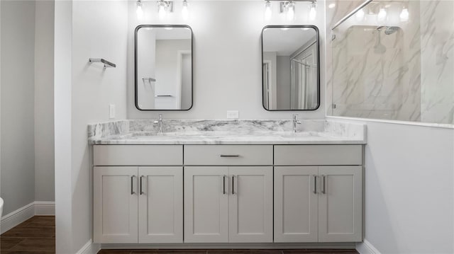 577 Dowling Cir, Lady Lake, FL 32159 - bathroom featuring double vanity, baseboards, wood finished floors, and a shower