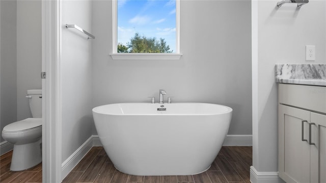 bathroom with toilet, vanity, a bath, and wood-type flooring