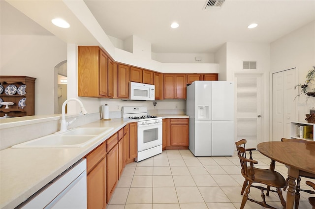 kitchen featuring light tile patterned floors, sink, and white appliances