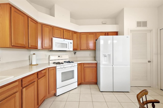 kitchen with white appliances and light tile patterned floors